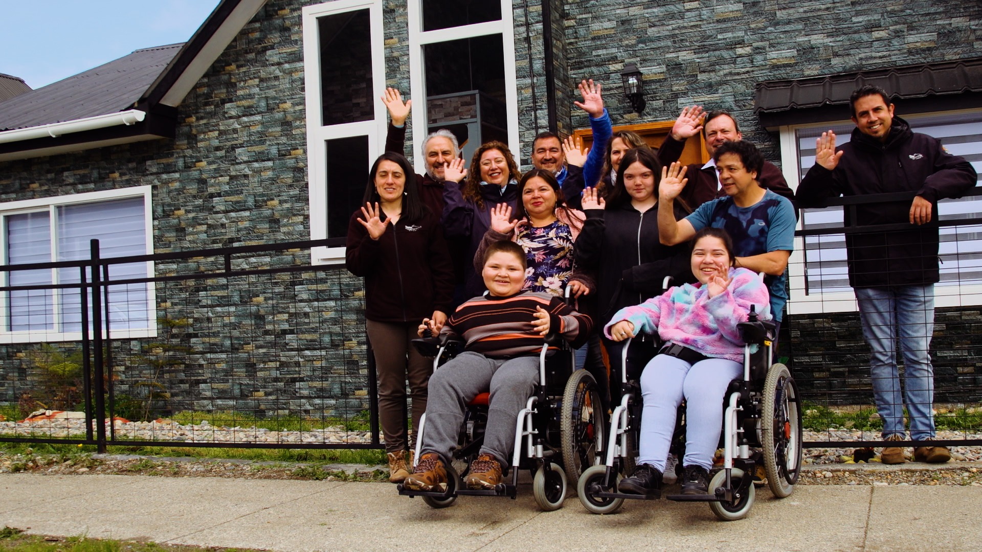 Personas de la comunidad reunidas frente a una sede, en un proyecto documental de Cooke Chile