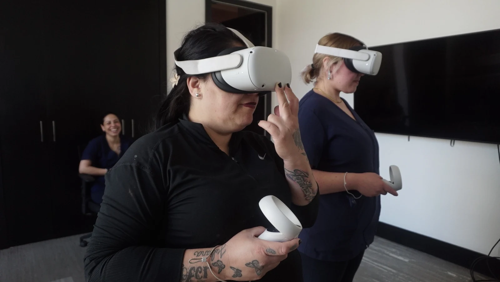 Dos participantes utilizan visores y controles de realidad virtual durante una sesión